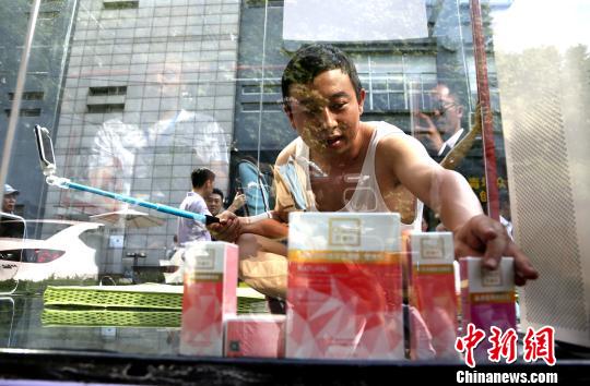 图为创业者安鸿先生在透明玻璃房子里用手机直播自己24小时生活。 张畅 摄