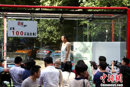图为创业者安鸿先生在透明玻璃房子里用手机直播自己24小时生活。 张畅 摄