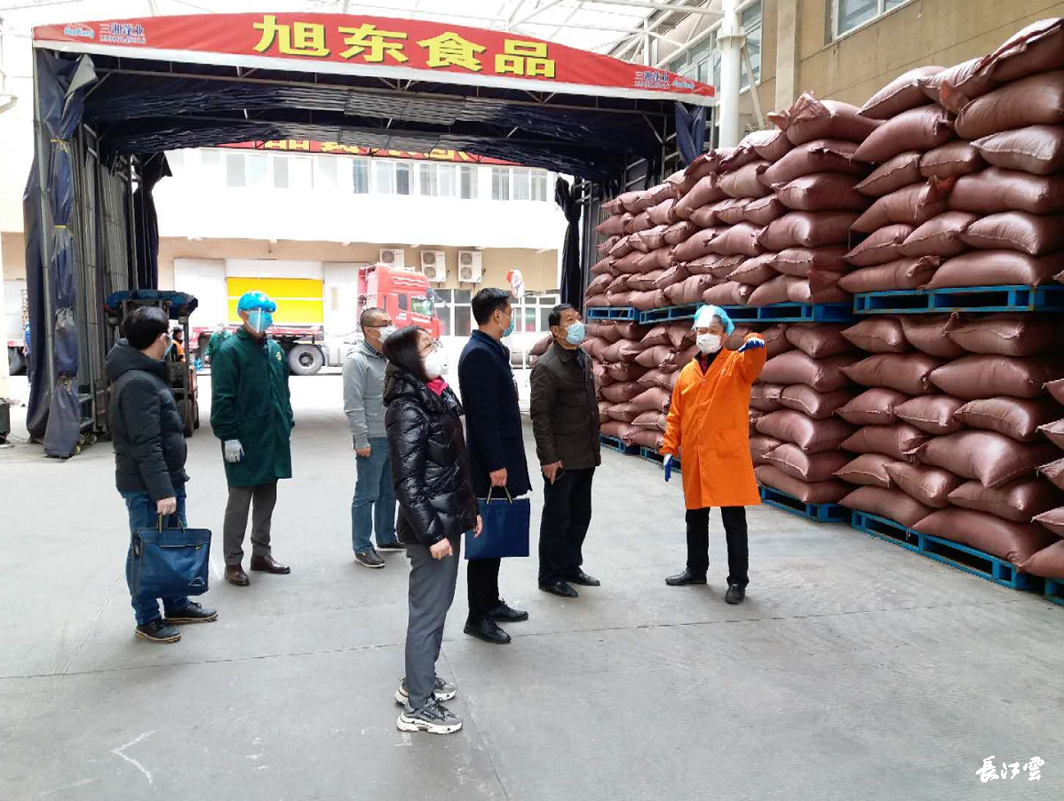 在武汉旭东食品有限公司,工人们身着全套防护装备,依次进场作业.