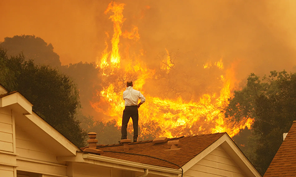 屋顶上的一名男子正在观看即将发生的火灾图