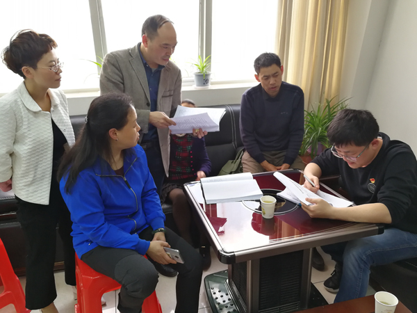 图为调查组在市扶贫办核实扶贫资金审计整改数据资料