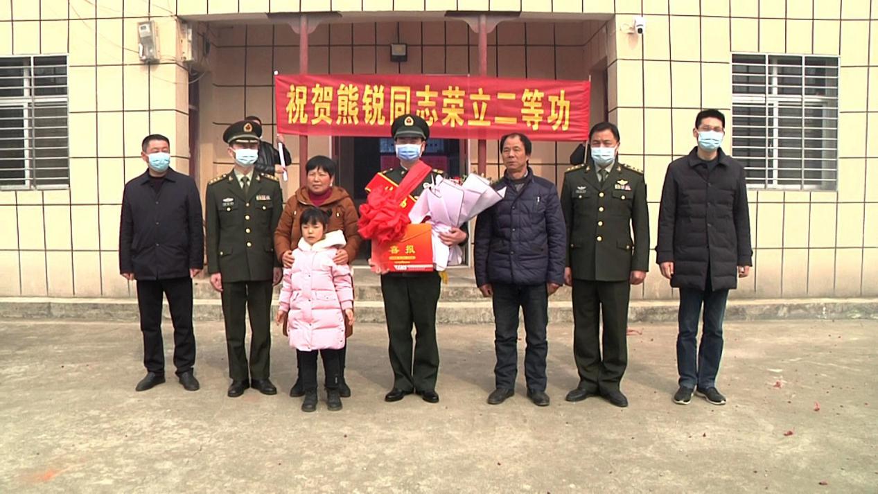 在"祝贺熊锐同志荣立二等功"条幅的引领下,伴随着一路振奋人心的敲锣