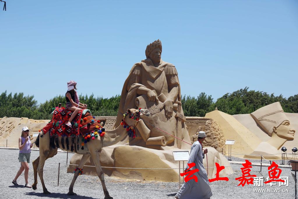 7月4日,游客在埃及红海省胡尔加达市的沙雕城参观.