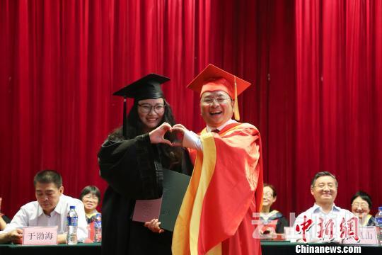 “合体比个心。”学生和院长“合体比心”拍照留念。　钟欣 摄