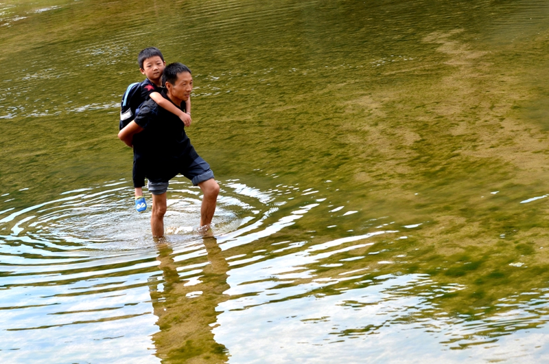 驼背教师坚持22年背着学生过河