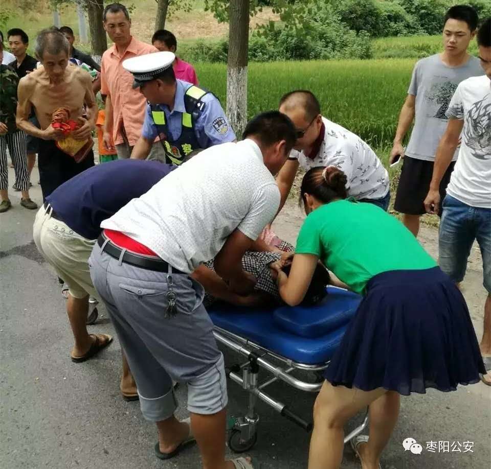 枣阳一妇女车祸受伤昏迷 交警撑伞保护等待救援