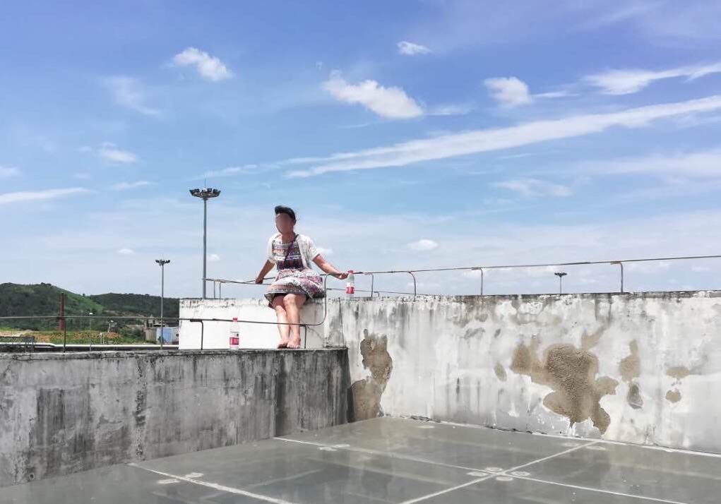 接警后,民警迅疾赶到现场,发现轻生女子坐在天台外沿上,双脚悬空,情况