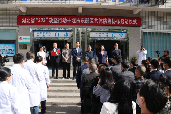 牌匾并合影图为出席领导共同为十堰市人民医院东院区"知名中医工作室"