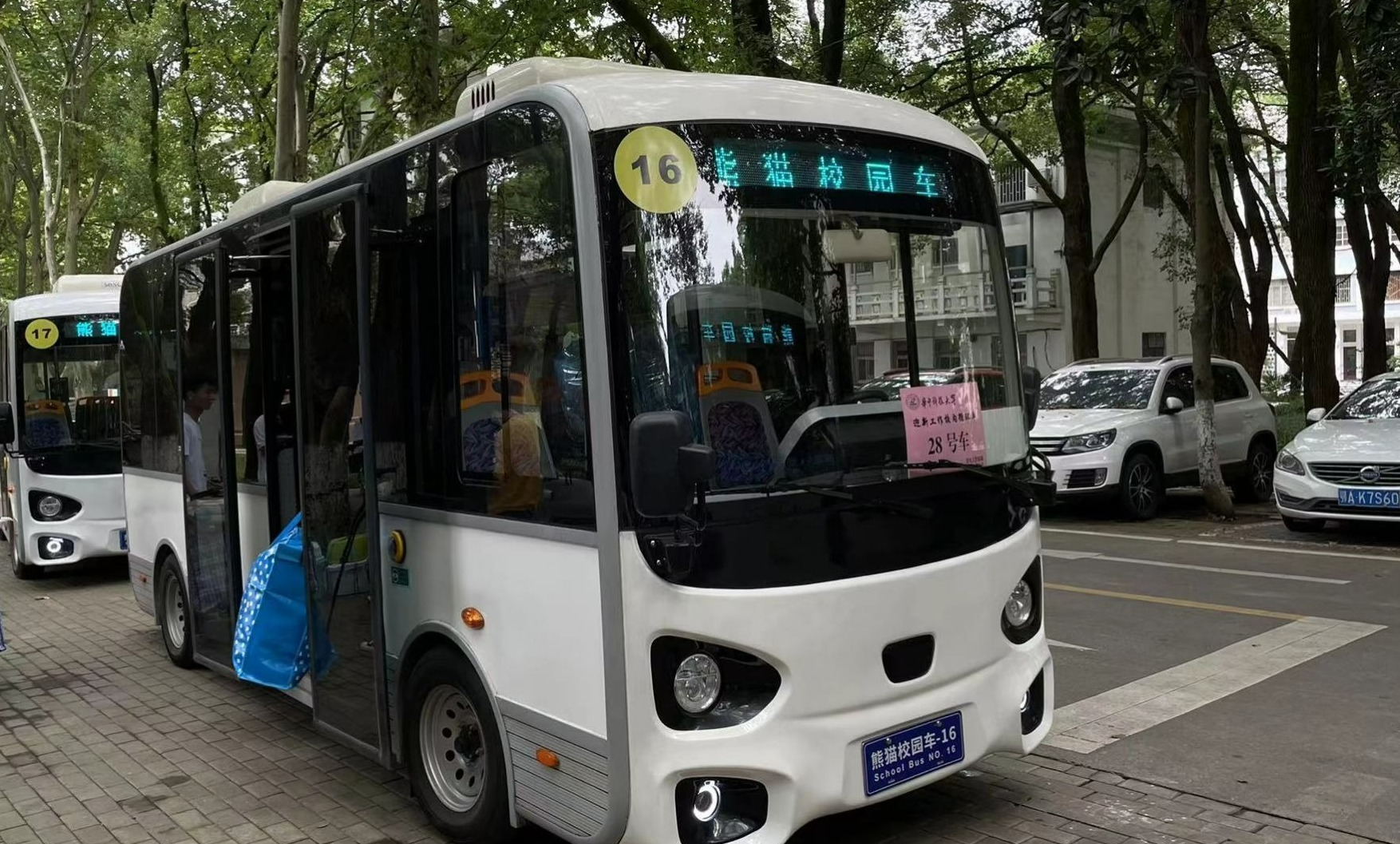 在校内车站,一辆辆黑白分明的"熊猫校园车"有序开行,将新生们送到指定