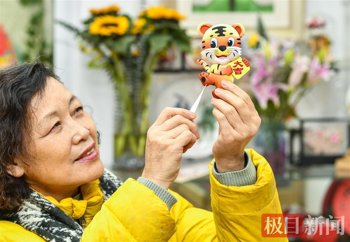 制作布艺堆绣的底板,将不同颜色的布剪,缝,绣,贴出丰富多样的虎像作品