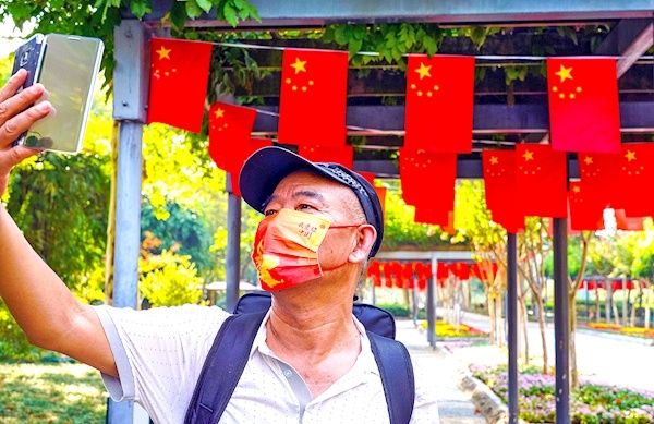 公園紅旗招展鮮花芬芳撲面滿眼中國紅映出幸福和喜悅