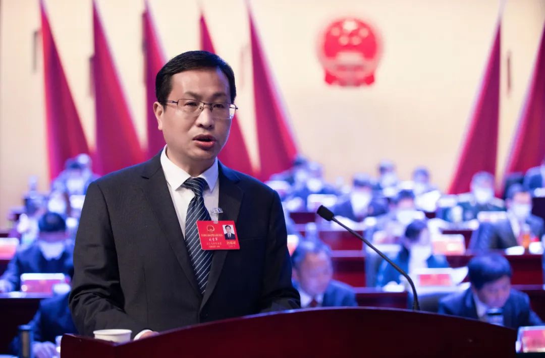 在热烈的掌声中,县长刘堂军代表县人民政府作工作报告.