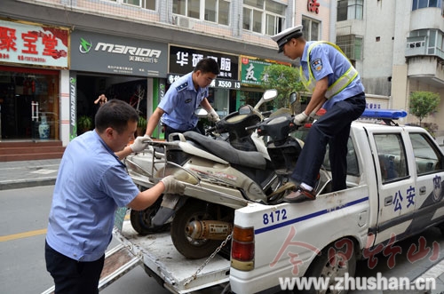 城区人行道上8台“僵尸车”被拖走