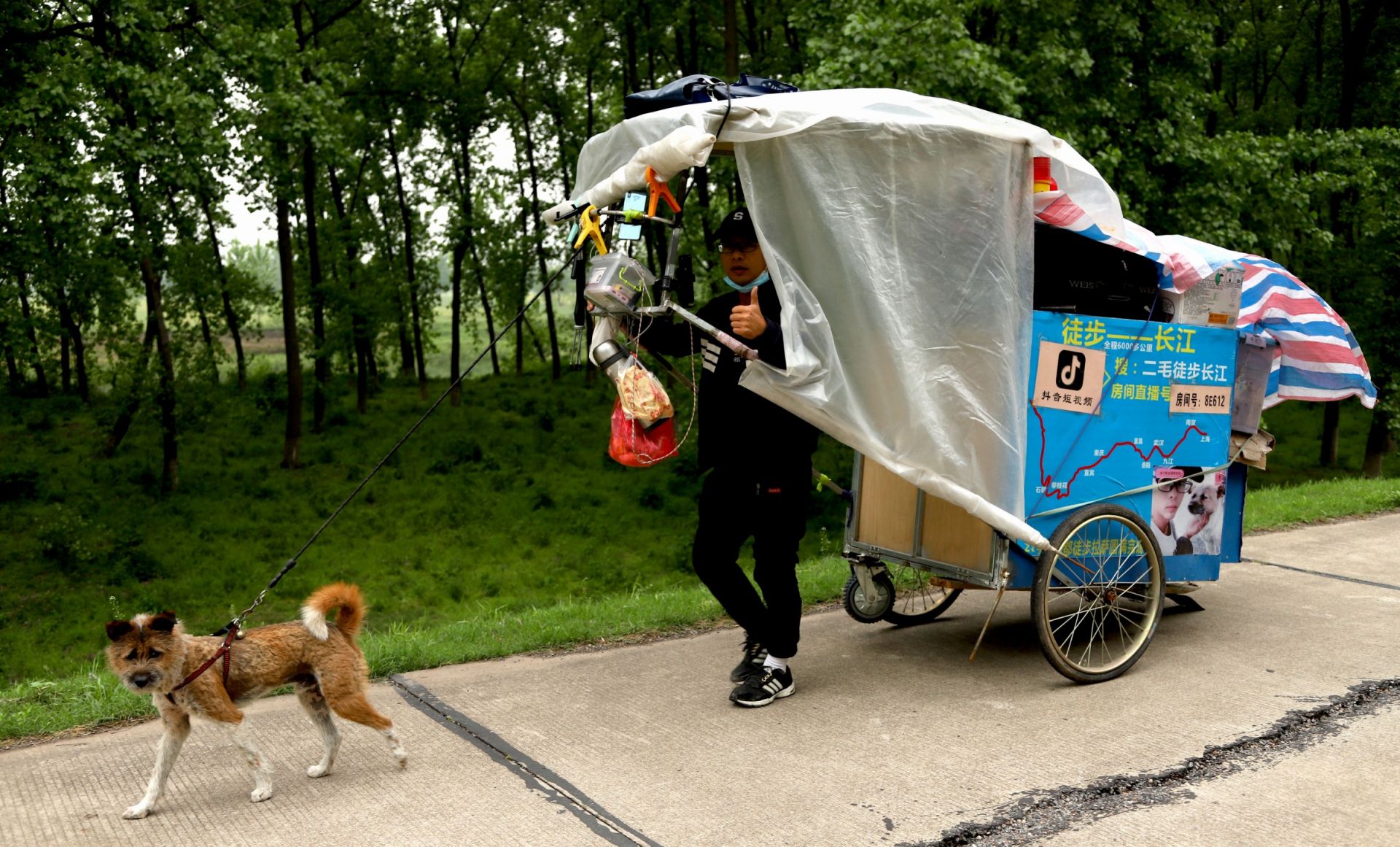拉车带上生活用品,牵着爱犬"二毛",于2019年11月5日出发挑战徒步长江