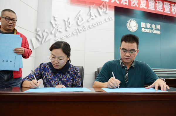 谢成校(右一)与乡镇相关负责人签订灾后恢复重建责任状10月20日,巴东