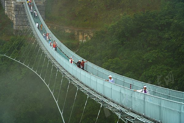 7月3日,长江三峡巫峡口景区,游客行走在壮观的玻璃廊道上,体验人在
