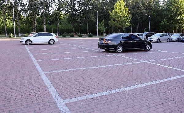 吴都春天小区南门外,市政设施管理处工作人员正在步道砖上施划停车位