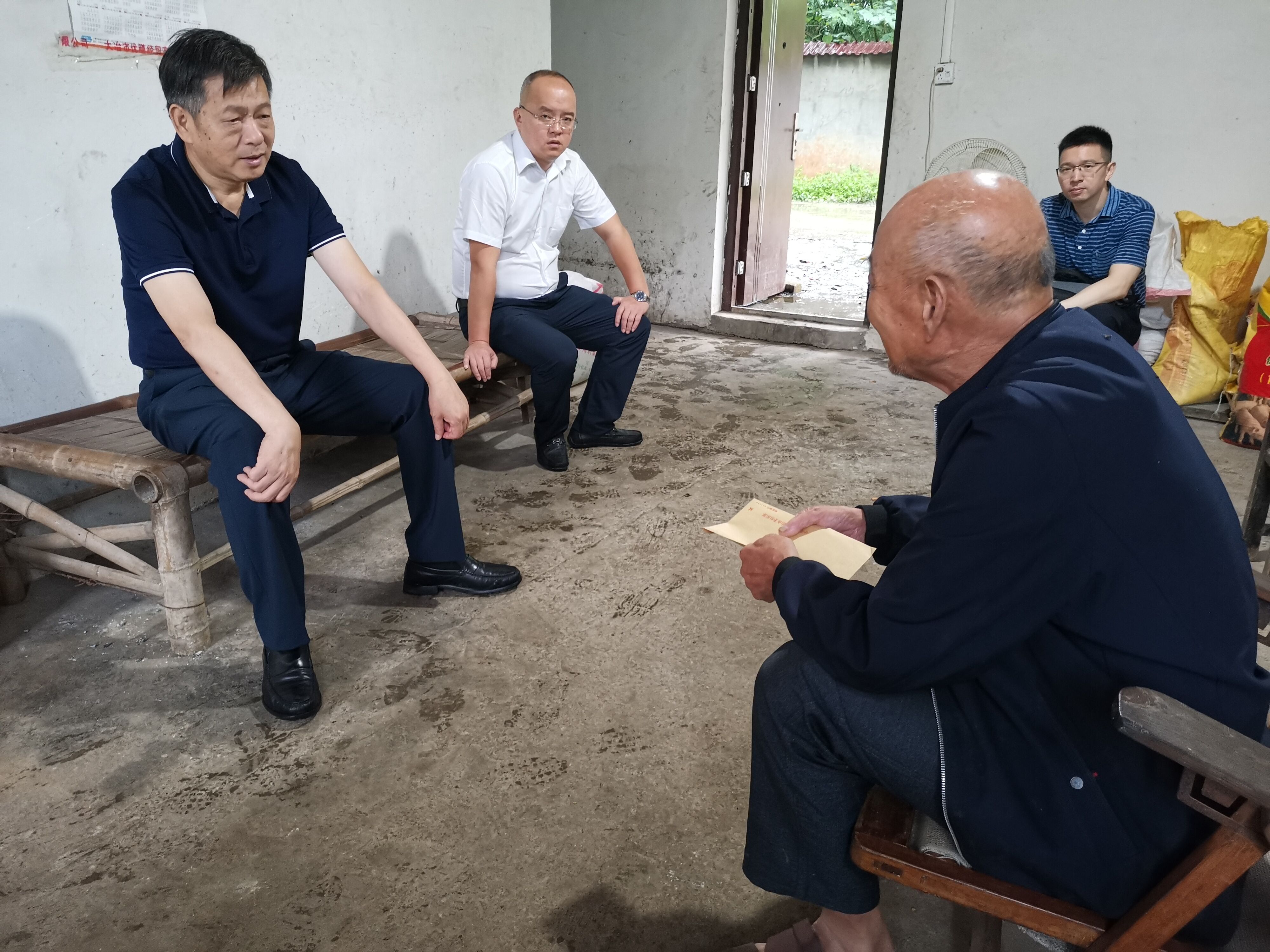 在新建村困难党员黄开义家中,江龙平与他亲切交谈,关切地询问老人的
