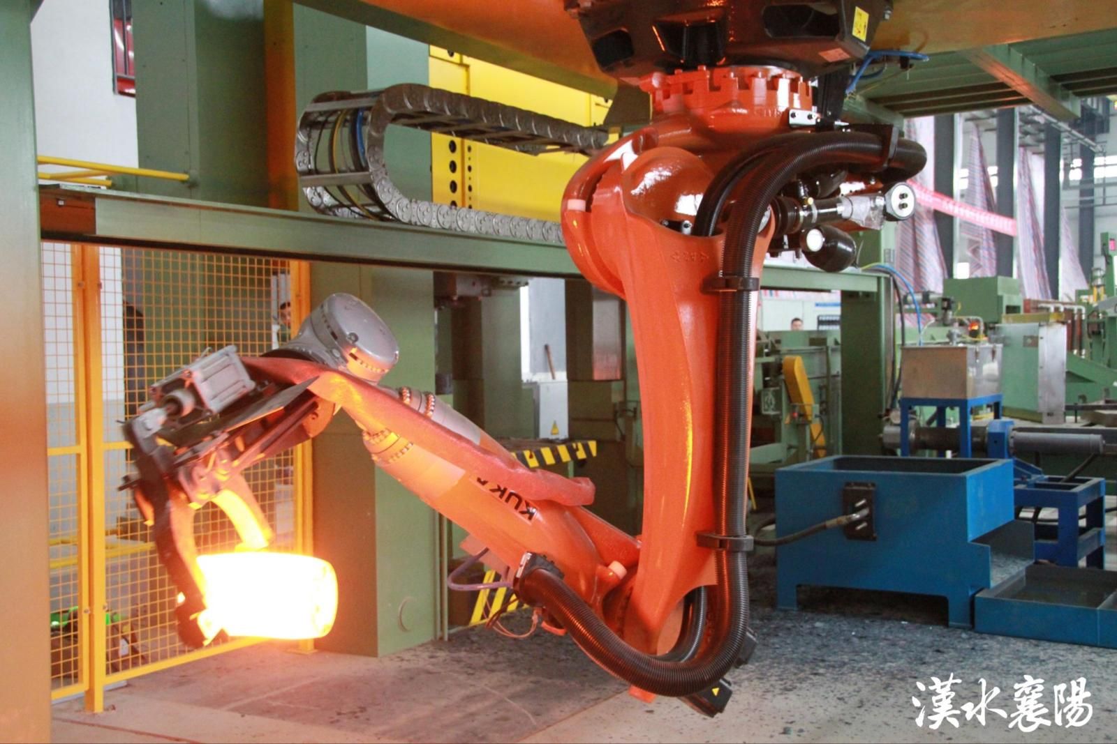 ▲湖北三环锻造有限公司(简称三环锻造)数字化生产车间,工业机器人伸展灵活的臂膀,精准夹起通红的锻件
