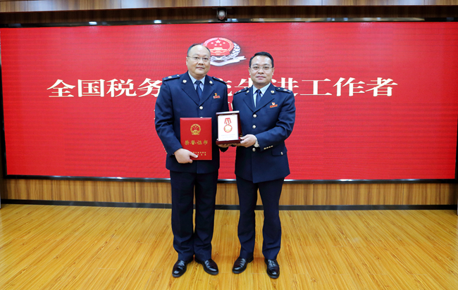 黄石市税务局党委书记,局长傅晓东为阮中华颁发奖牌和证书全国税务
