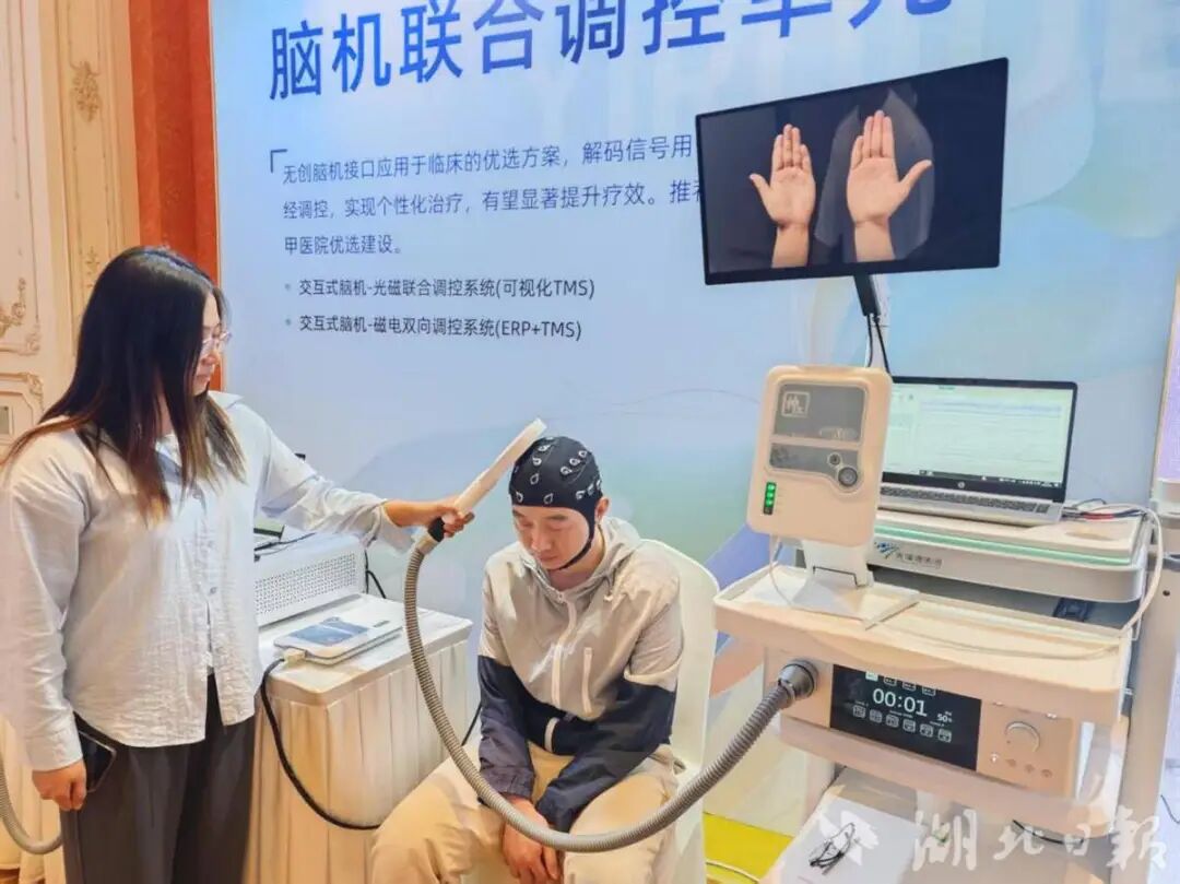 体验者戴上脑电帽,通过运动想象触发经颅磁刺激治疗。(记者刘洁摄).png