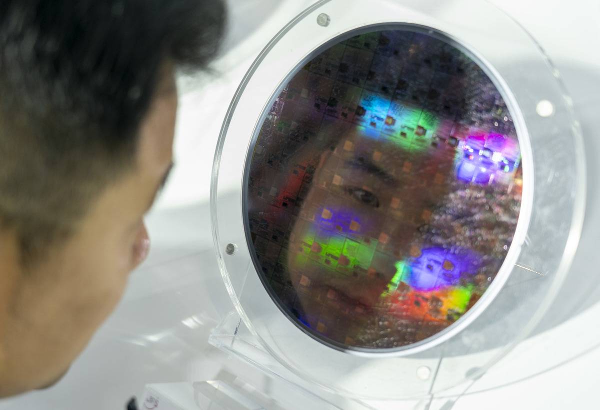 九峰山实验展台，一位观众仔细参观新型化合物半导体晶圆。（湖北日报全媒记者 魏铼 摄）.jpg