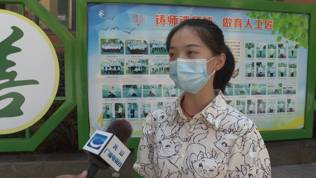 兴山一中学校门口设置了体温监测点,志愿者们在监测点负责查验健康码