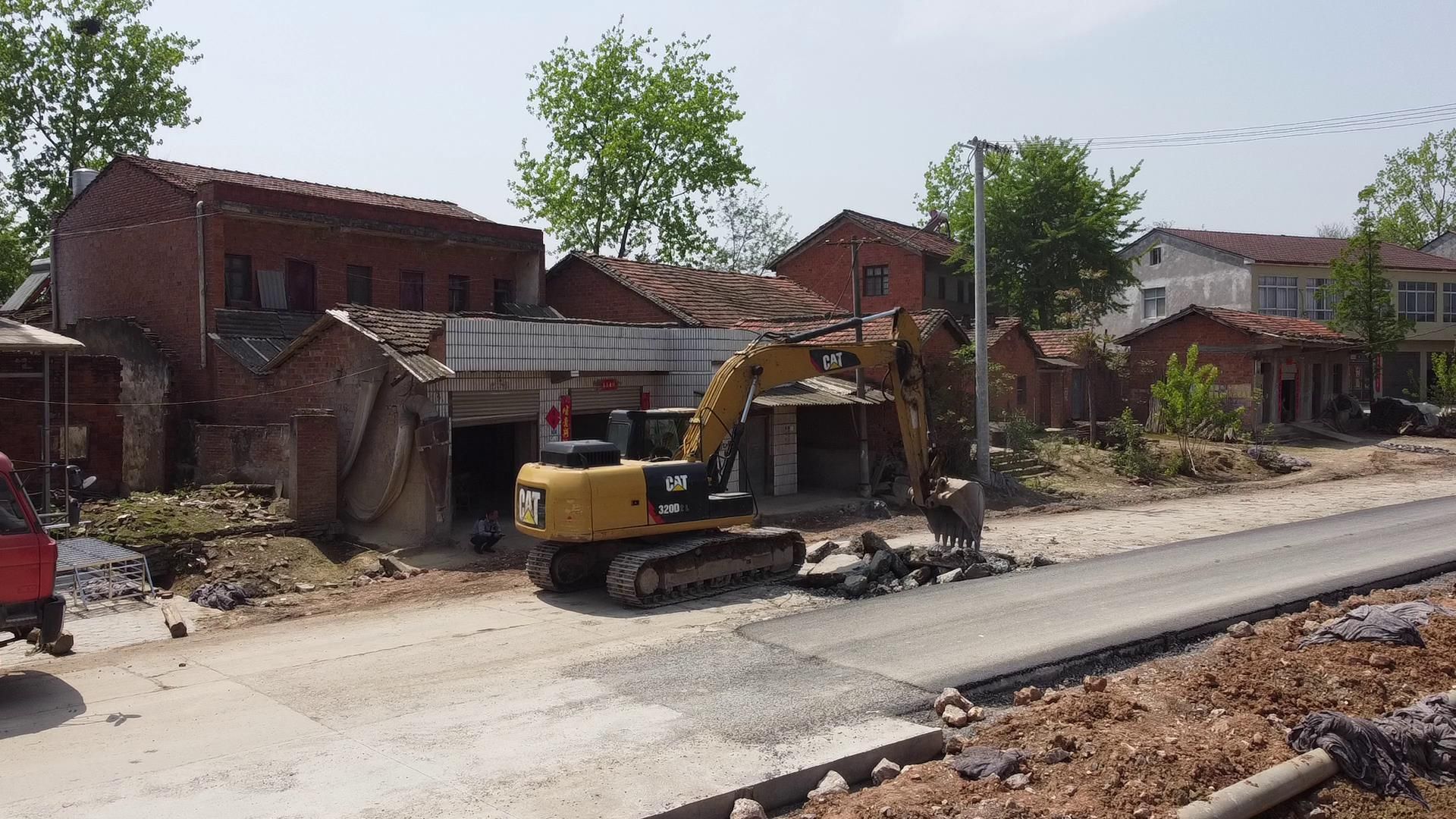 在武安镇花门楼村二组通村公路的施工现场,工人正在铺设水泥路面,整个