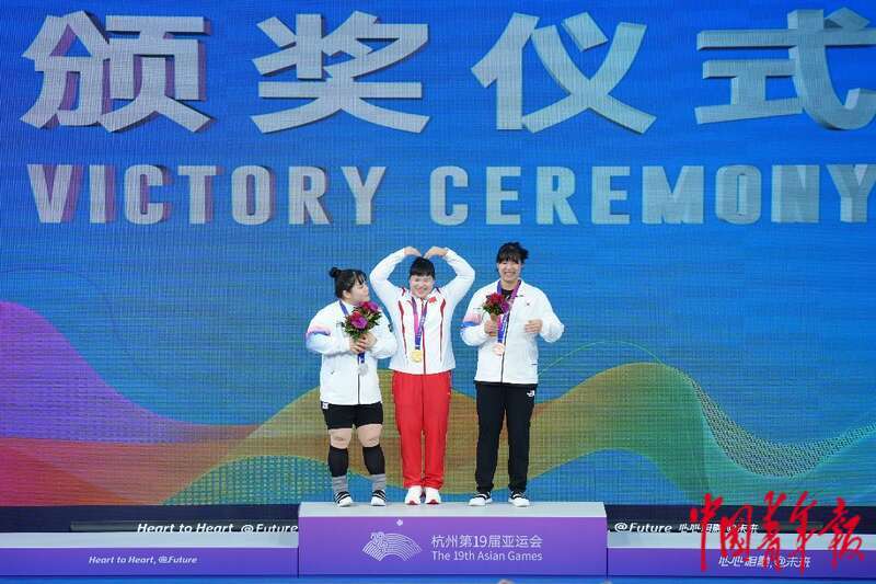 10月6日,杭州亚运会举重女子87公斤级决赛颁奖仪式,梁小梅(中)向现场