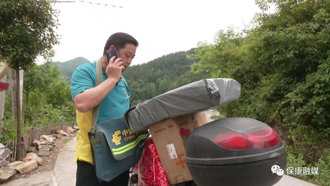 乡邮员黄德印骑着摩托来回奔波一个挎包装满嘱托