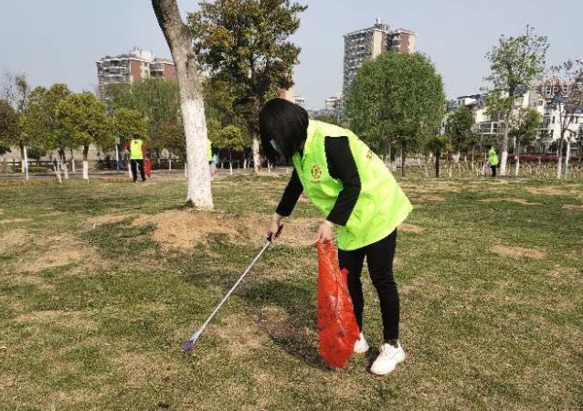 孝昌志愿者公园捡拾垃圾倡导环保从我做起