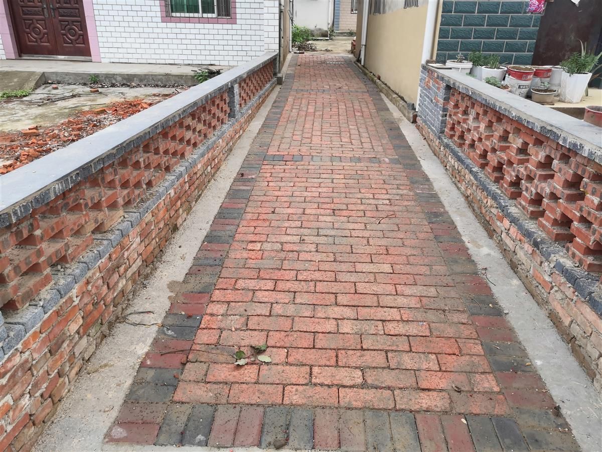 过去,巷道都是泥巴路,现在这红砖铺装路通到家门口,造型独特且接地气