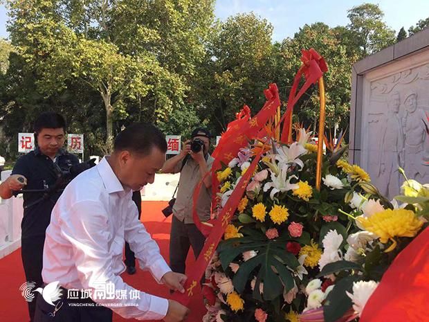 图为市委书记程涛神情庄重地走向纪念碑整理缎带,表达对革命先烈的