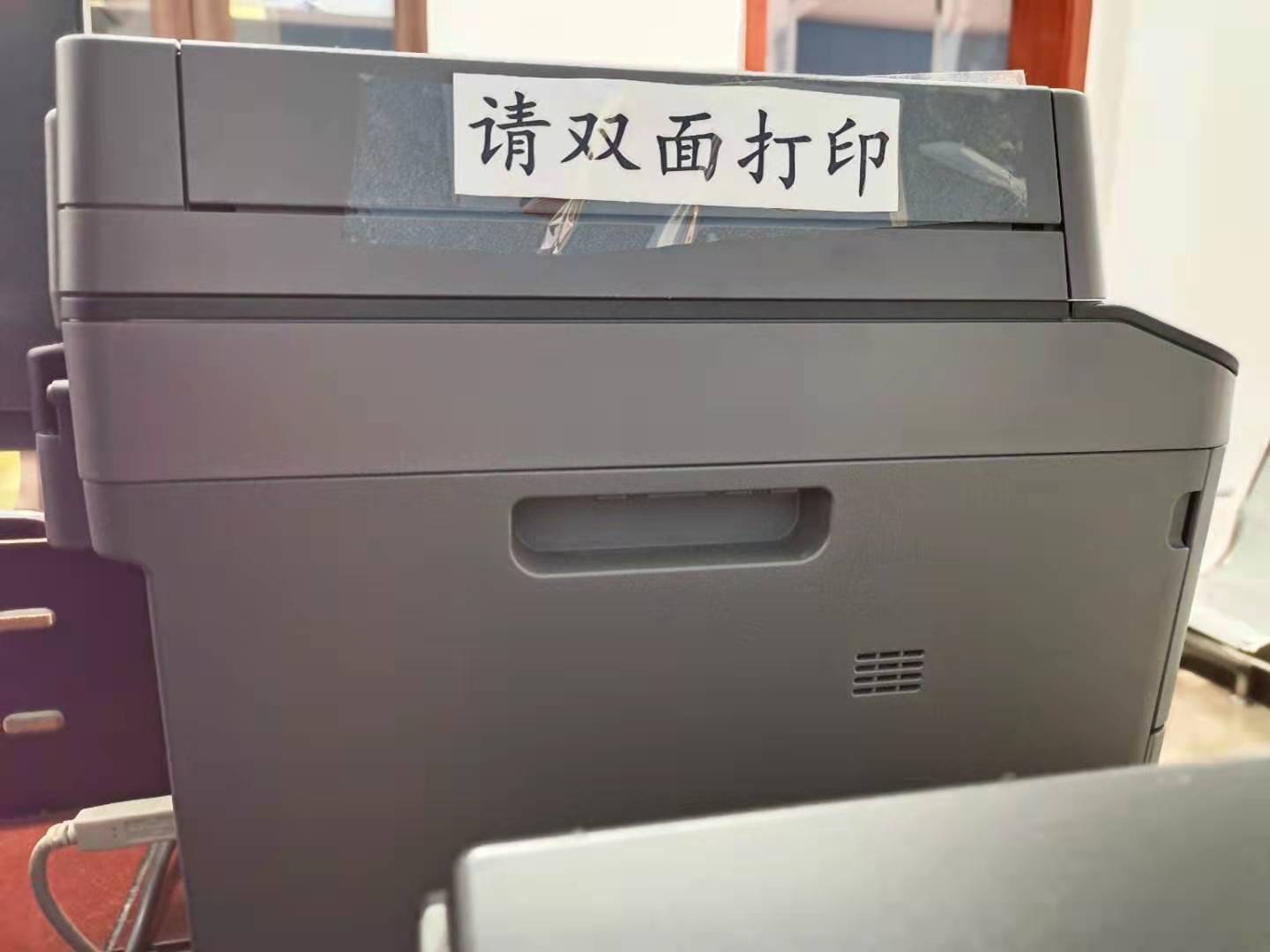 龙泉镇农业农村发展局在局办公室打印机处张贴"请双面打印"宣传标语