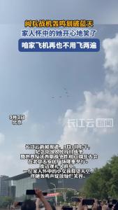 阅兵战机轰鸣划破蓝天，家人怀中的她开心地笑了