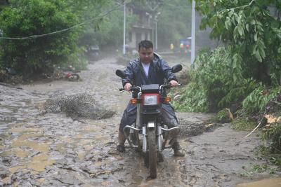 挺进白水河村，记者在暴雨中路遇一位“骑士”