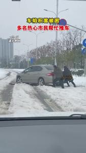 车陷积雪被困 多名热心市民帮忙推车
