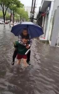 暖心！暴雨中 小伙来回蹚水背行人