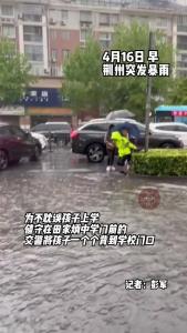 荆州突发暴雨 交警蹚着水将孩子们送到学校门口