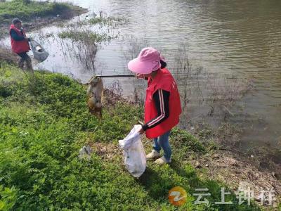 钟祥市东桥镇团山村网格员化身“环卫工”清理河道沿线垃圾