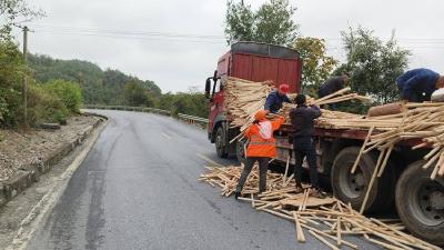 半挂车侧翻木料撒落　养路工及时救援保畅