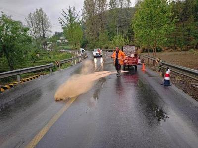 县公路部门冒雨清理路面油污保畅通