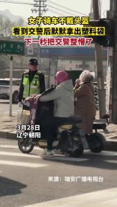 女子骑车不戴头盔，看到交警后默默拿出塑料袋……