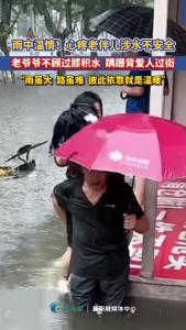雨中温情：老爷爷蹒跚涉水背老伴儿过街