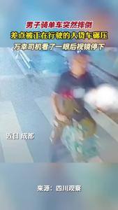 男子骑单车突然摔倒 差点被正在行驶的大货车碾压