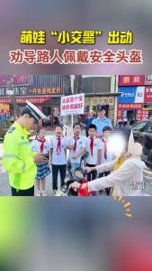 萌娃“小交警”出动 劝导路人佩戴安全头盔