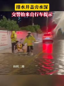 7月1日晚，强降雨过后，黄石港区纺织二路排水井盖正在放水，由于积水深，交警抬来自行车做警示提示。