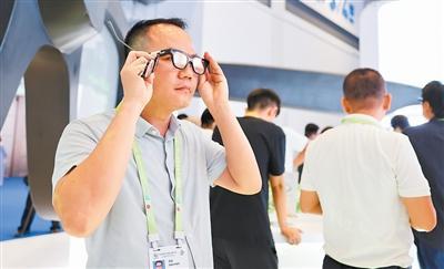 记者现场体验消博会展出的新品——科技激发消费新动能