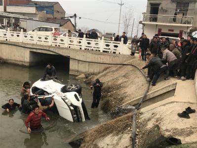 轿车翻入河中，40余名村民上演“拔河式”救援